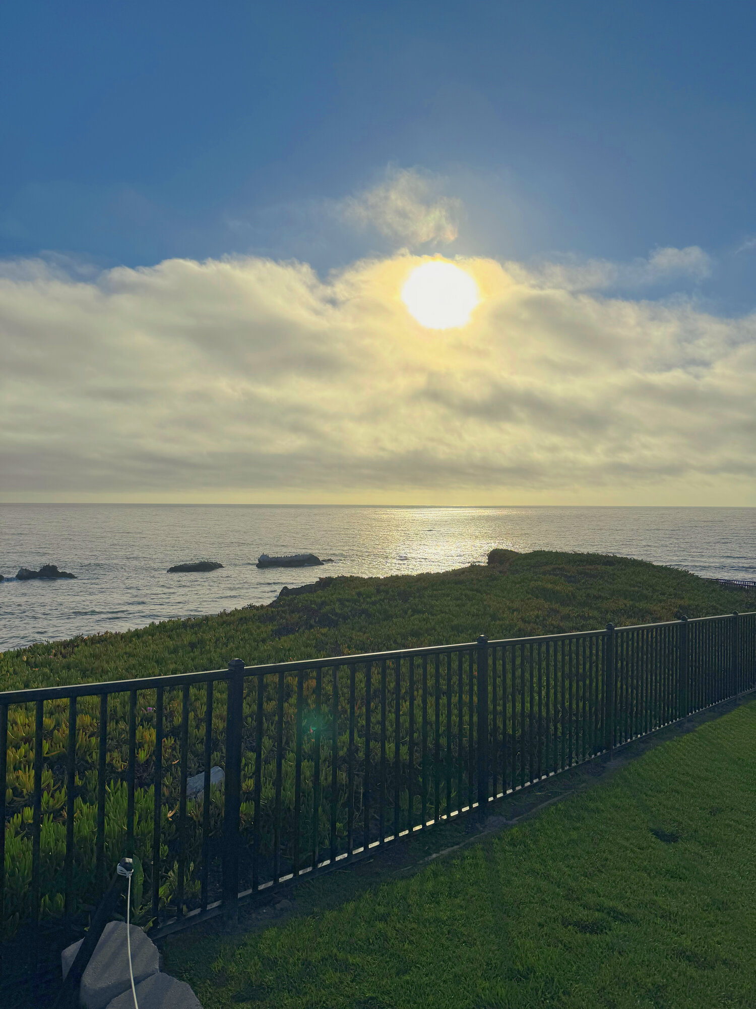 Late afternoon sun breaking through clouds above the sea